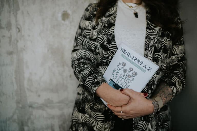 Grief coach, Blair Kaplan Venables, holding her book, RESILIENT A.F.